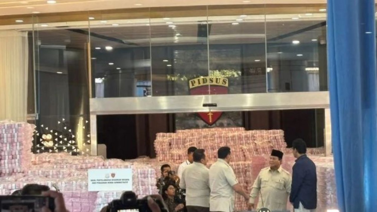 Presiden Prabowo Subianto berbincang dengan para menteri di depan tumpukan uang hasil denda administratif Satgas PKH dan penyelamatan keuangan negara di Gedung Bundar, Kejaksaan Agung, Jakarta, Rabu 24 Desember 2025. ANTARA/Mentari Dwi Gayati (Antara)
