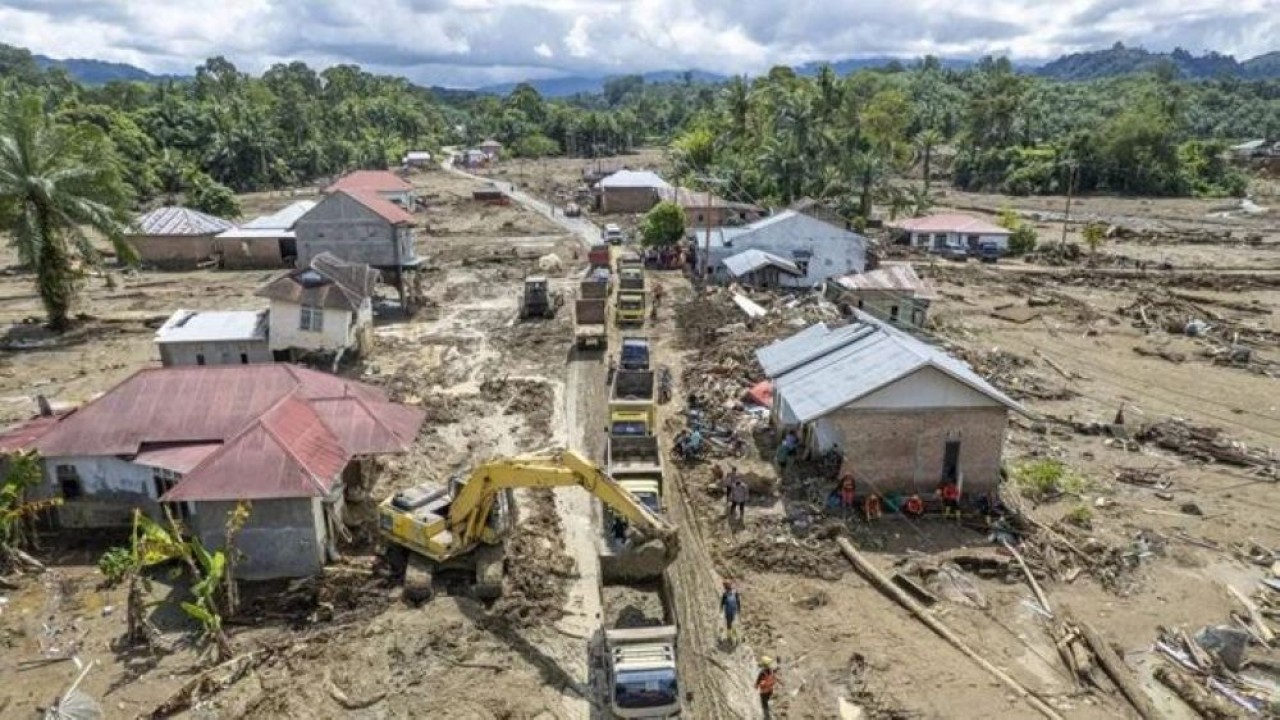 Foto udara alat berat membersihkan reruntuhan rumah, kayu, dan lumpur sisa bencana banjir bandang ke atas truk yang mengantre di Jorong Kayu Pasak, Nagari Salareh Aia, Palembayan, Agam, Sumatra Barat, Selasa 9 Desember 2025. (Foto: Antara)